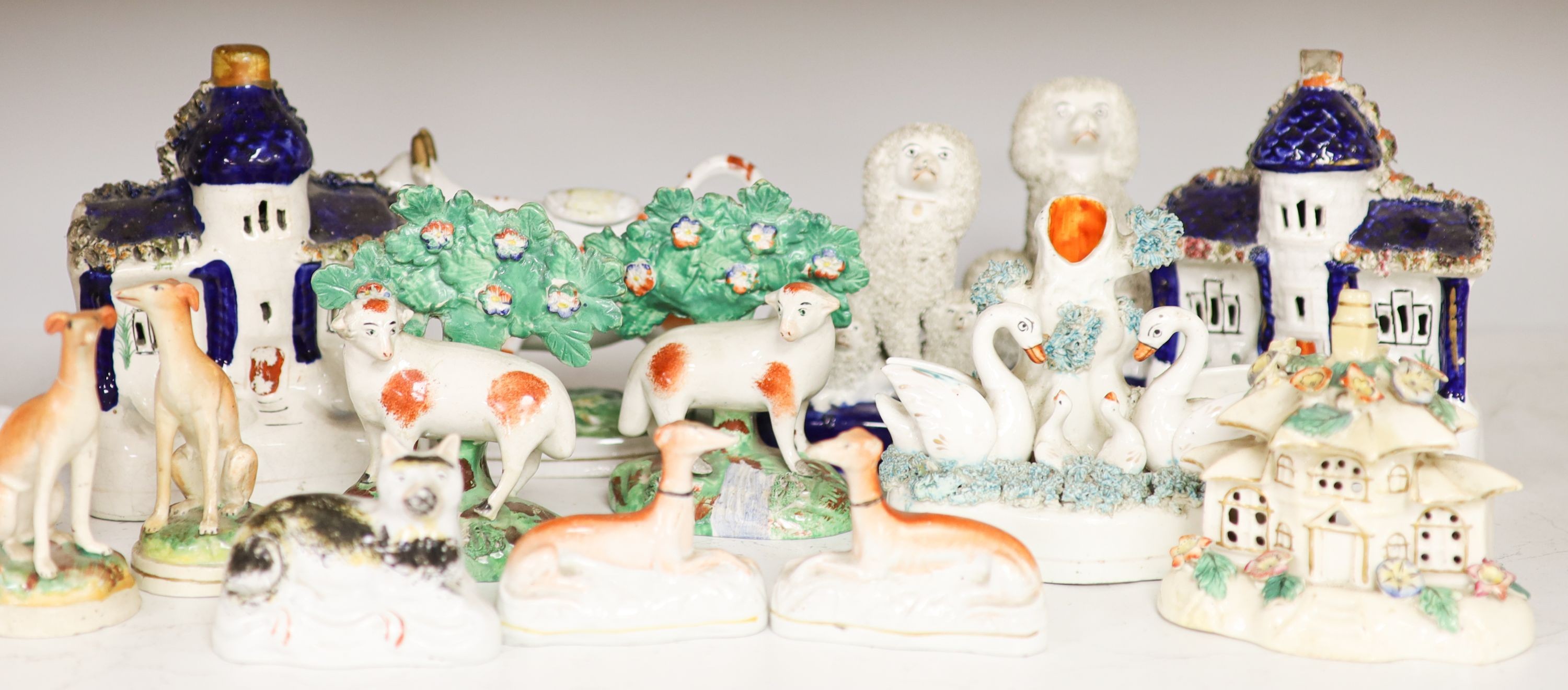 A collection of Victorian Staffordshire pottery to include a sponge glazed seated cat, a pair of bocage sheep, cow creamer etc (14).